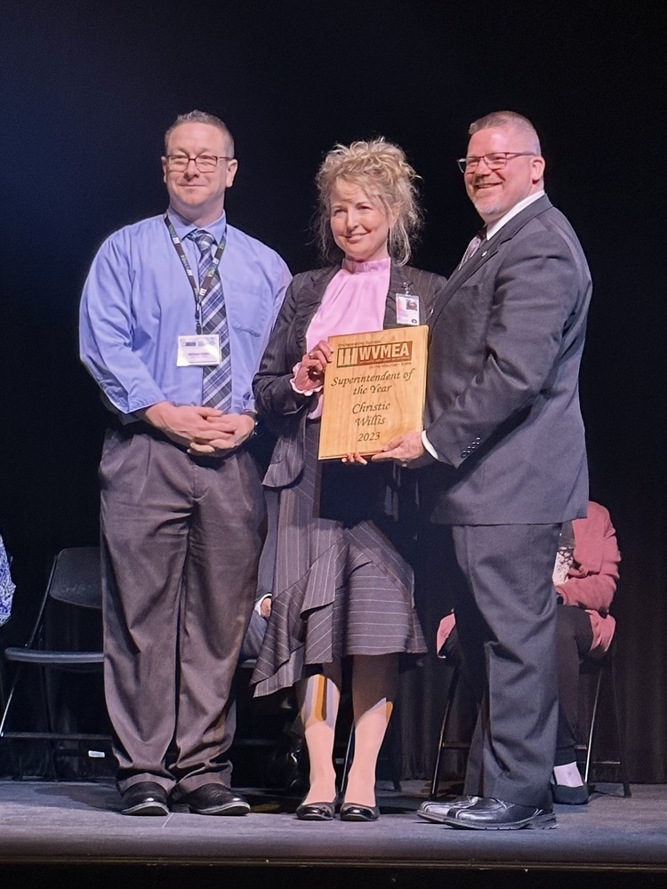 Wood County Schools Superintendent Christie Willis, center, was named Superintendent of the Year by the West Virginia Music Educators Association during a ceremony today in Charleston. The award was presented by WVMEA President Bobby Jenkins, right, and Blennerhassett Middle School music teacher and director William Cosby, left, who nominated Willis for this honor. 
